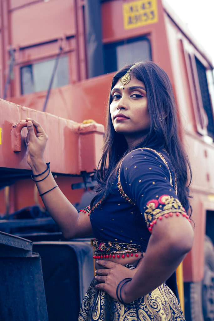 Woman in a navy embroidered blouse, maang tikka and gold lehenga