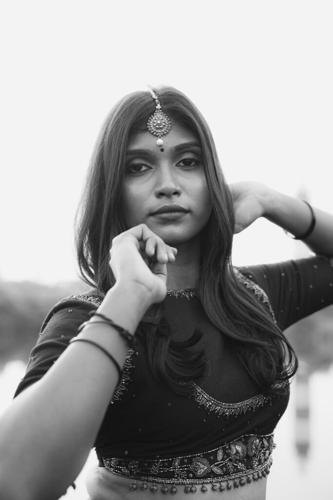 Woman in a navy embroidered blouse, maang tikka and gold lehenga