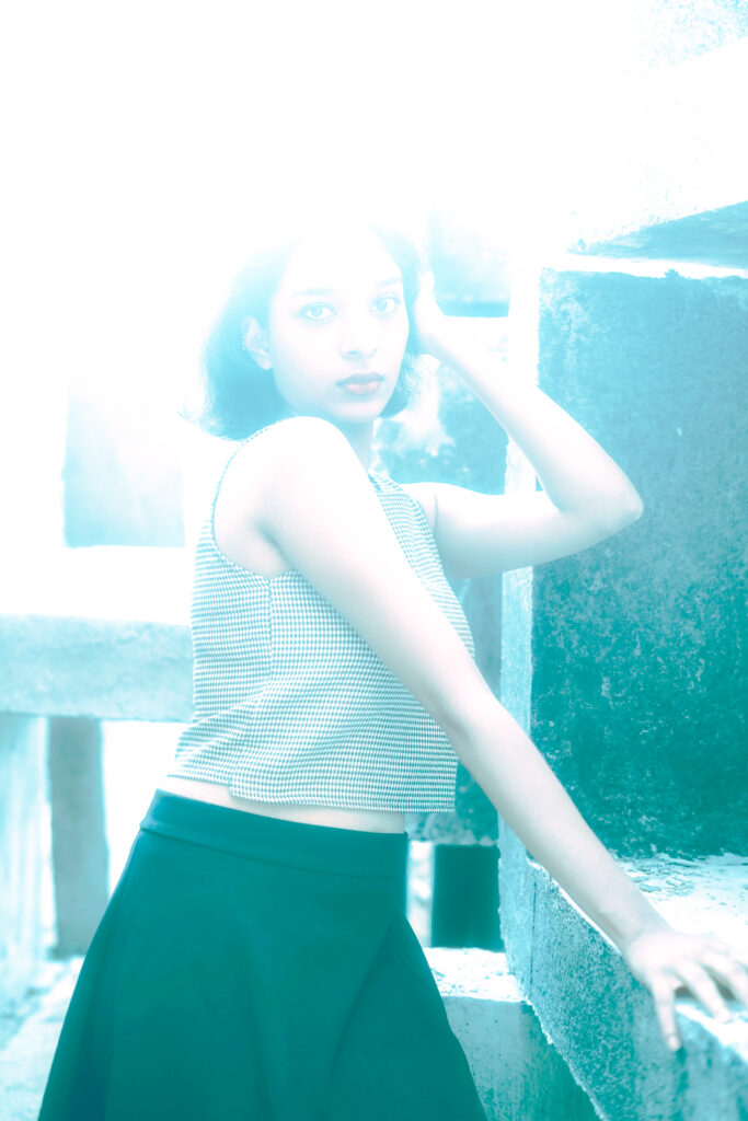 Woman in a striped knit top and black skirt among concrete blocks