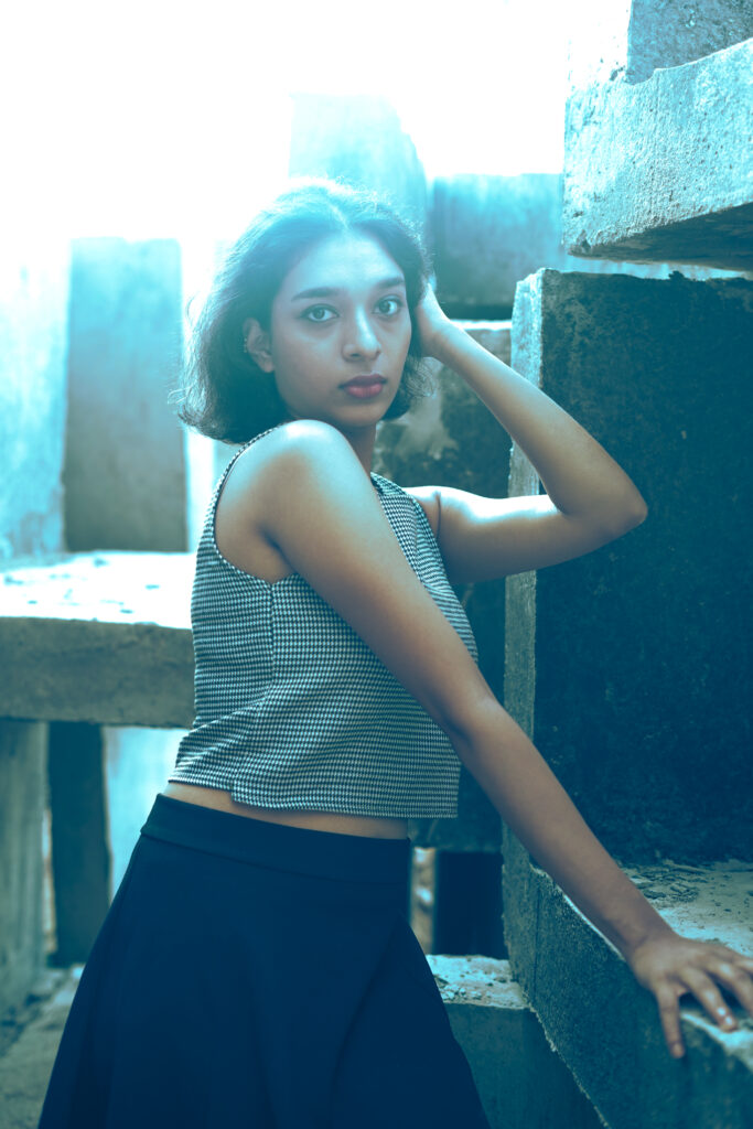 Woman in a striped knit top and black skirt among concrete blocks