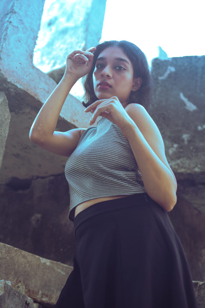 Woman in a striped knit top posing against weathered stone ruins