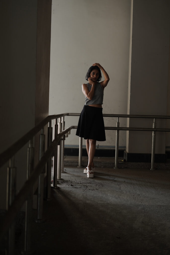 Woman in a striped knit top and black skirt in an urban setting