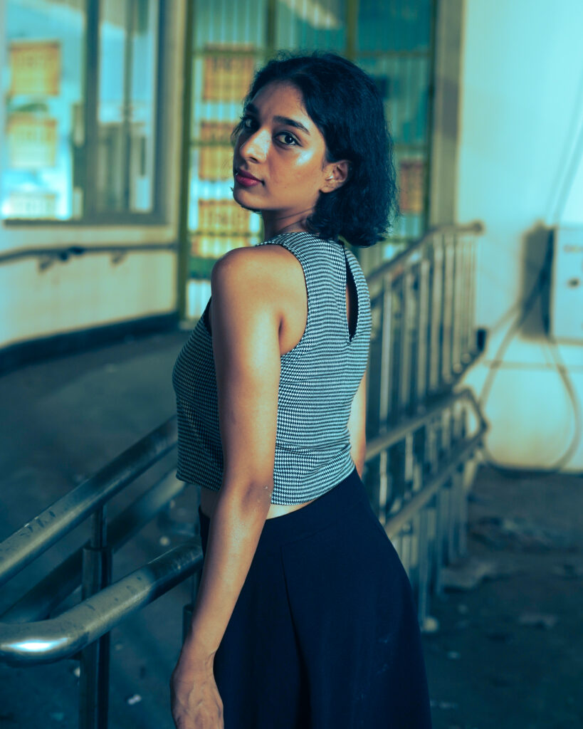 Woman in a striped knit top and black skirt in an urban setting