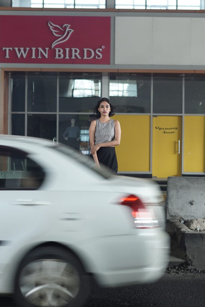 Woman in a striped knit top and black skirt in an urban setting