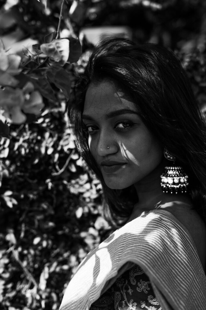 Black and white portrait of a woman with jhumka earrings and a saree