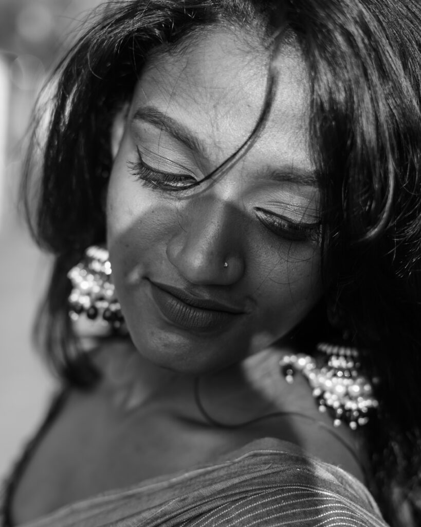 Black and white portrait of a woman with jhumka earrings and a saree