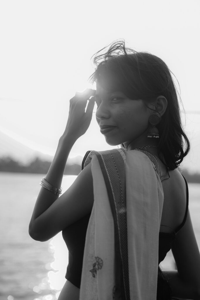 Black and white portrait of a woman in a saree by the river