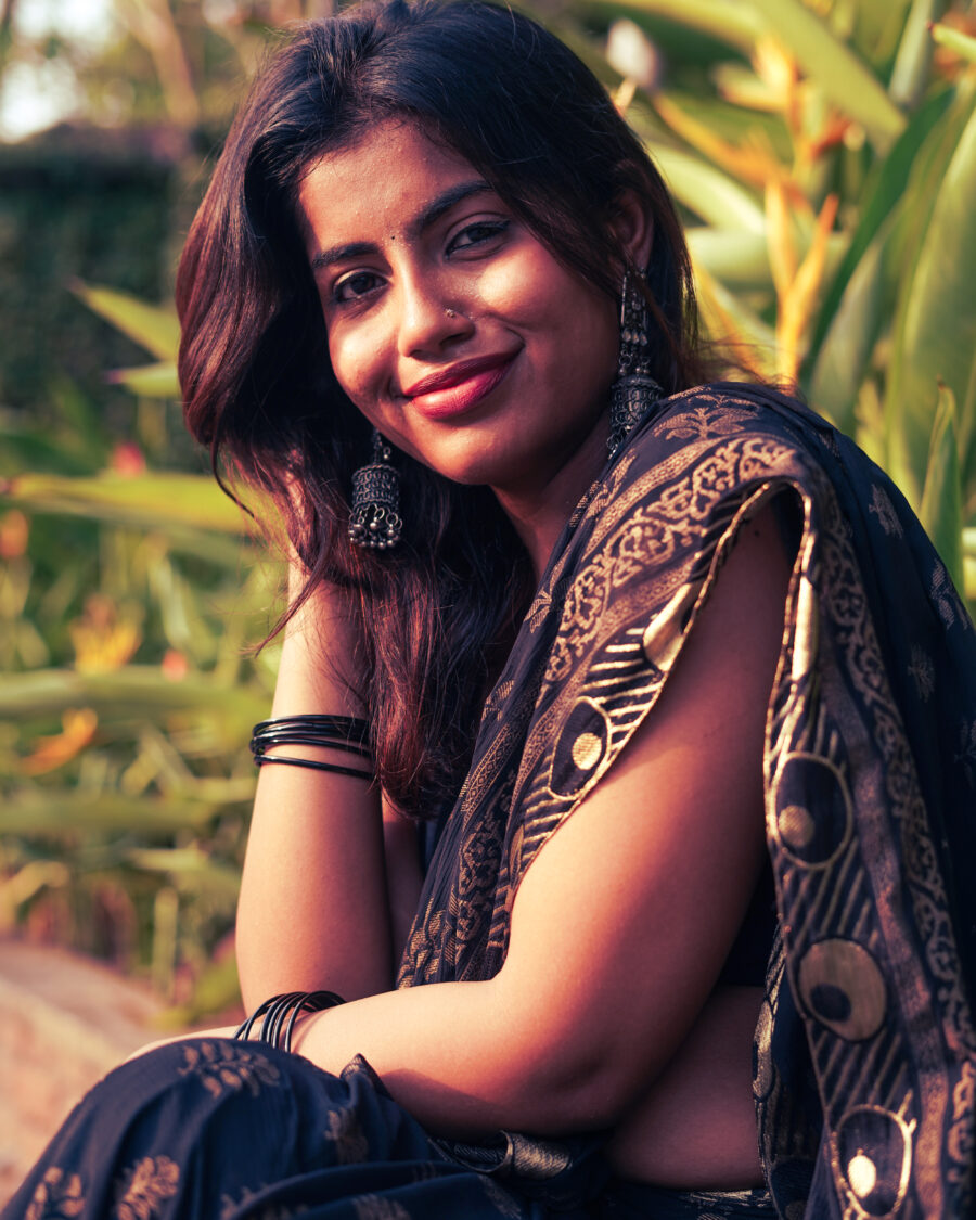 Portrait from a content shoot: a woman in a black and gold saree in evening light