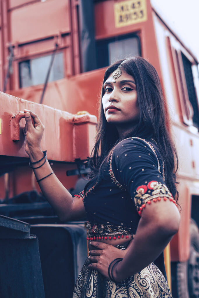 Woman in a navy embroidered blouse, maang tikka and gold lehenga