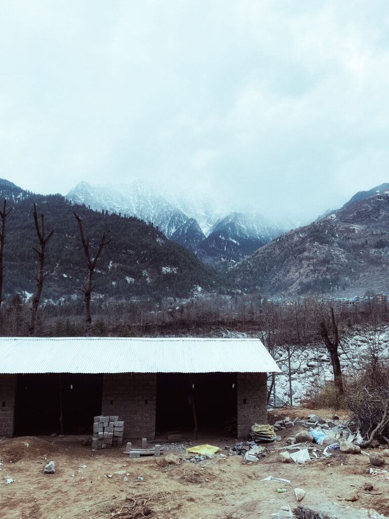 Snow-capped mountains above a small shed in a bare winter valley