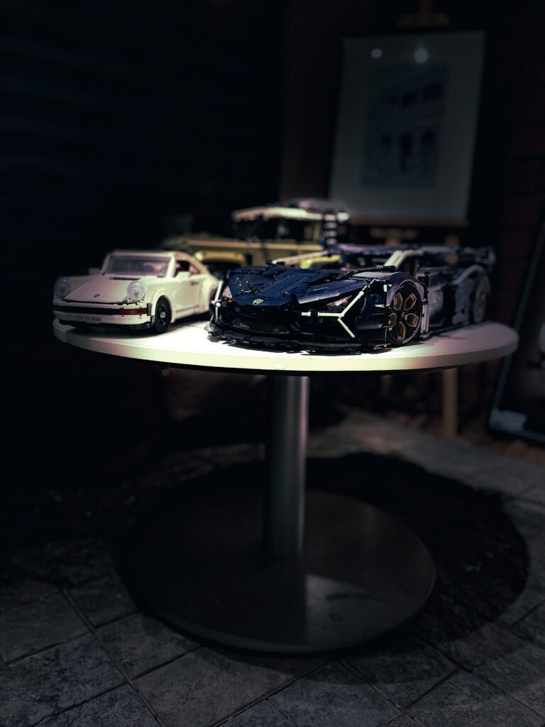 Model sports cars on a display table in a dim café