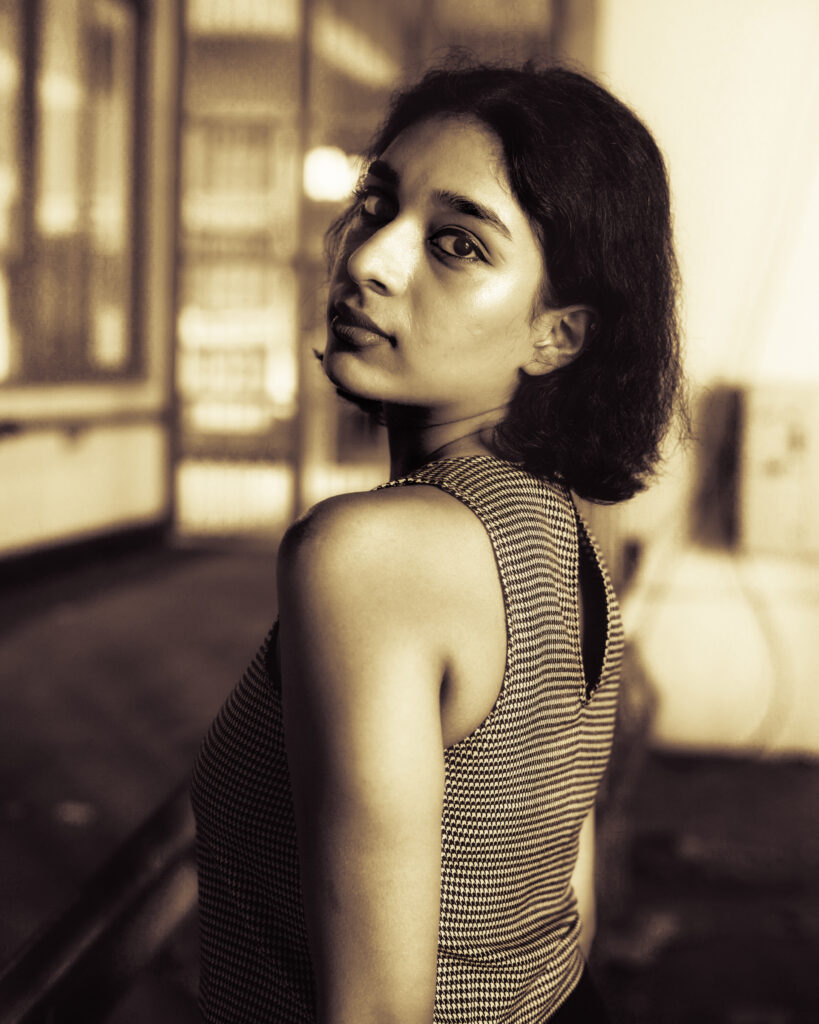 Sepia-toned editorial portrait of a woman with a short bob looking back over her shoulder